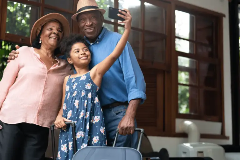 A granddaughter takes a selfie with her grandparents while they are traveling safely on summer vacation.