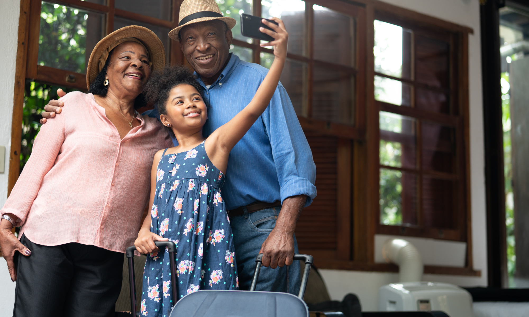 A granddaughter takes a selfie with her grandparents while they are traveling safely on summer vacation.