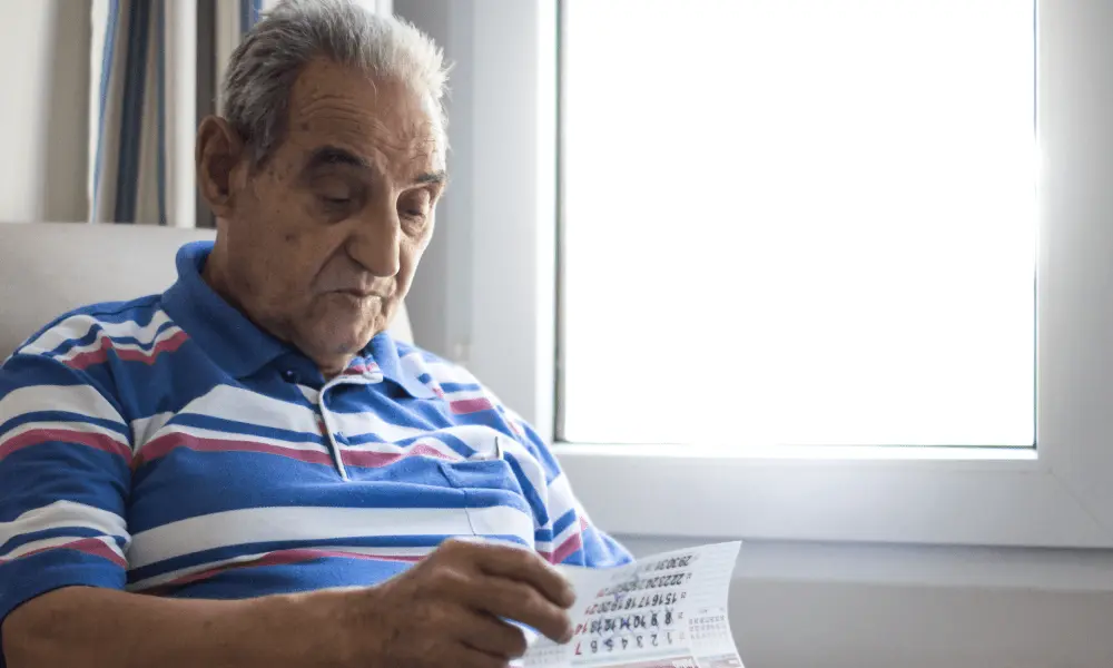 An older gentleman living with mild cognitive memory impairment flips through a calendar.