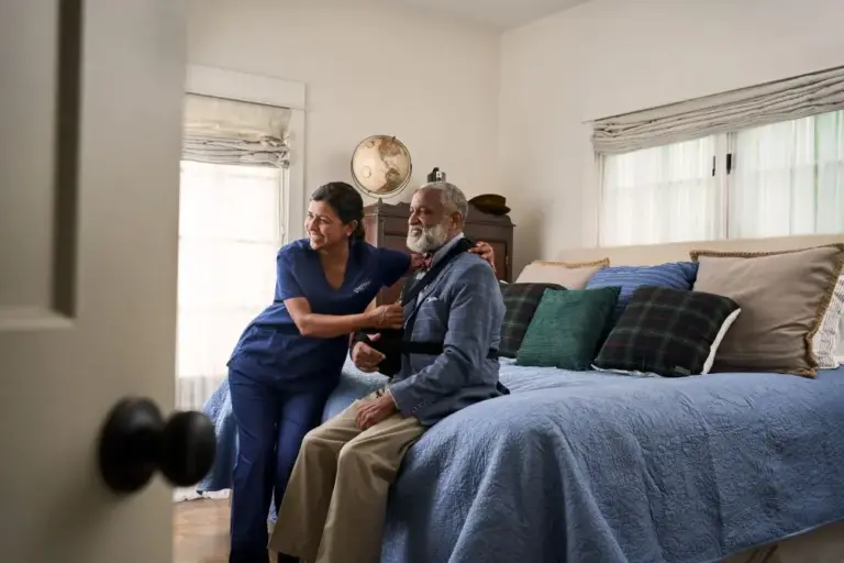 A caregiver adjusts a client's arm sling