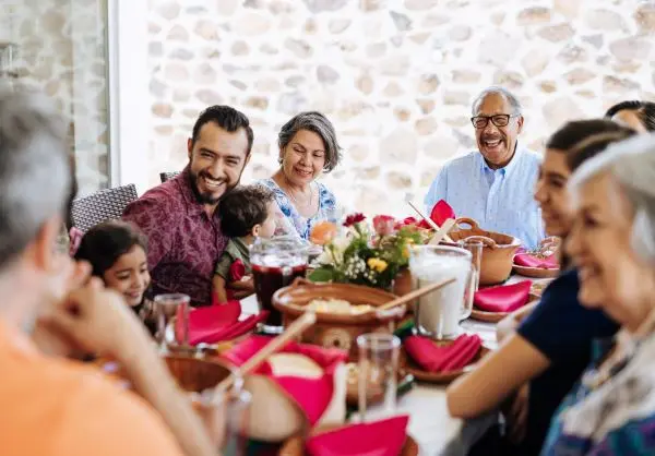 Smiling multigenerational family shares a meal together.