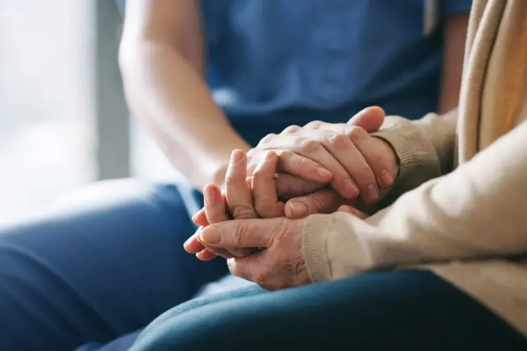 SYNERGY HomeCare client and caregiver holding hands