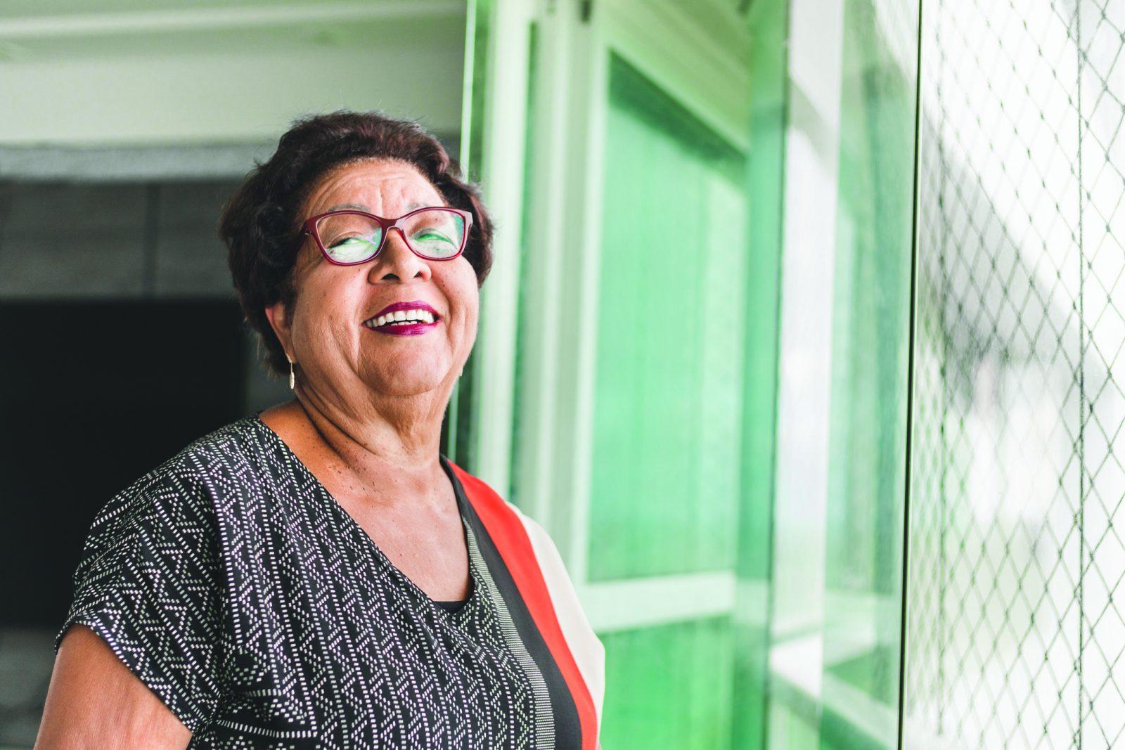 SYNERGY HomeCare client smiling looking out the windo.