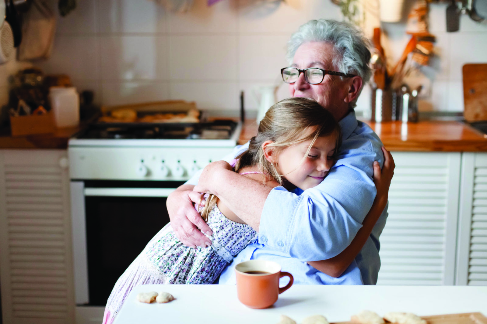 Grandmother hug child girl. Kid and senior woman baking in cozy home kitchen. Happy family