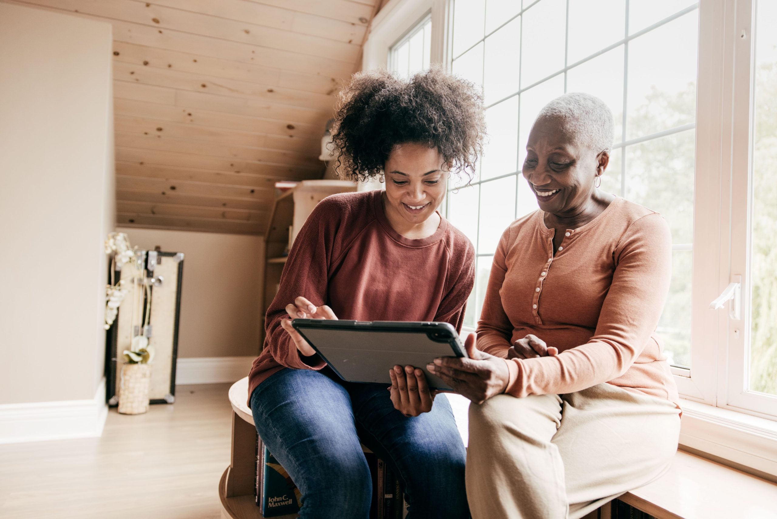 Senior woman and her daughter exploring home care cost.