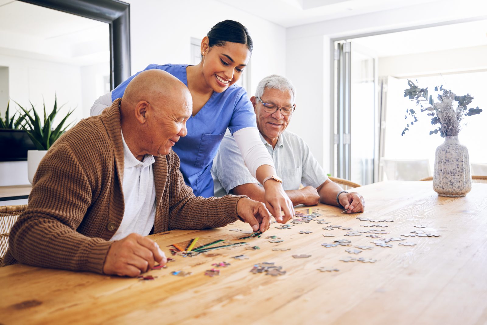 SYNERGY HomeCare caregiver doing a puzzle with two clients