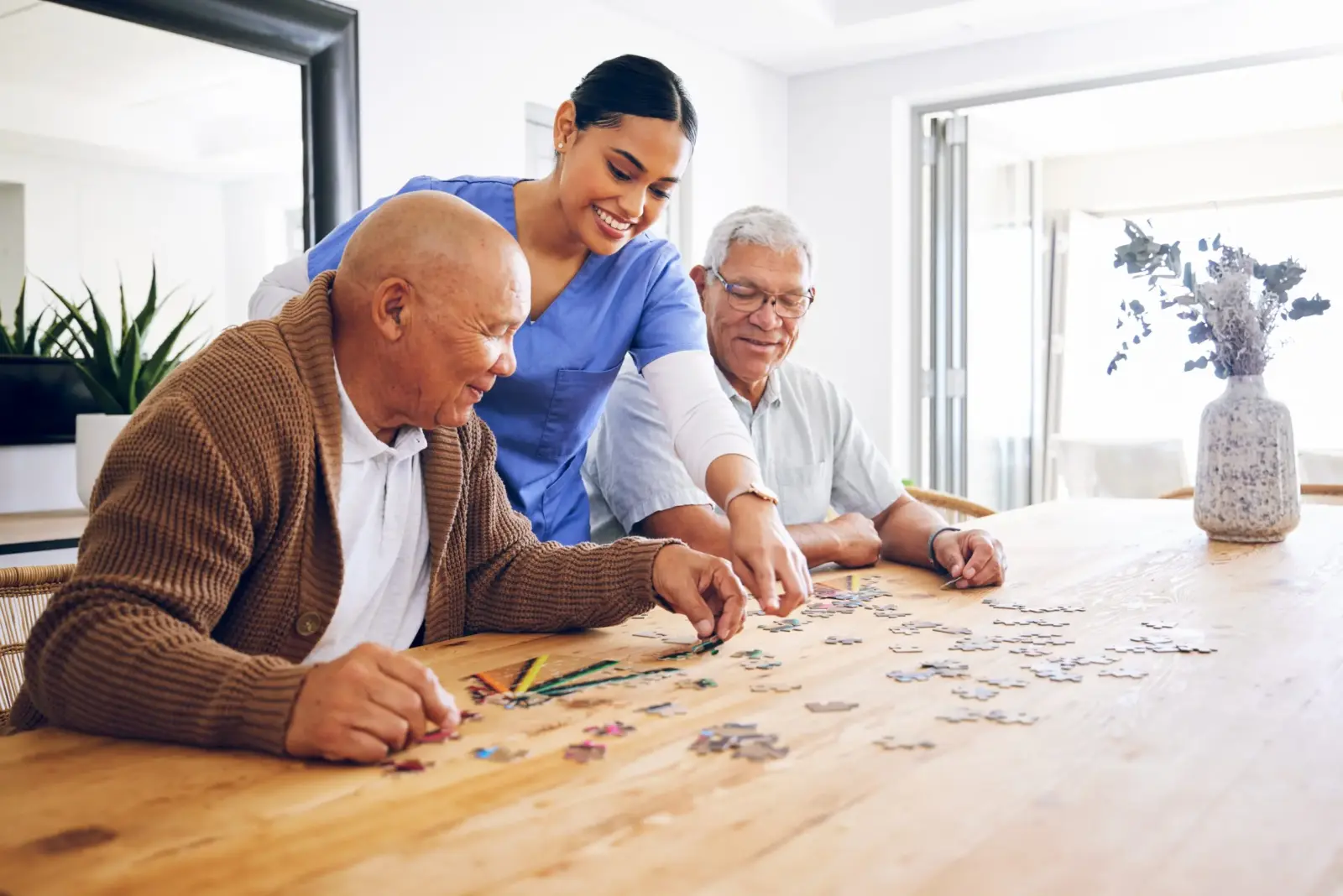 SYNERGY HomeCare caregiver doing a puzzle with two clients