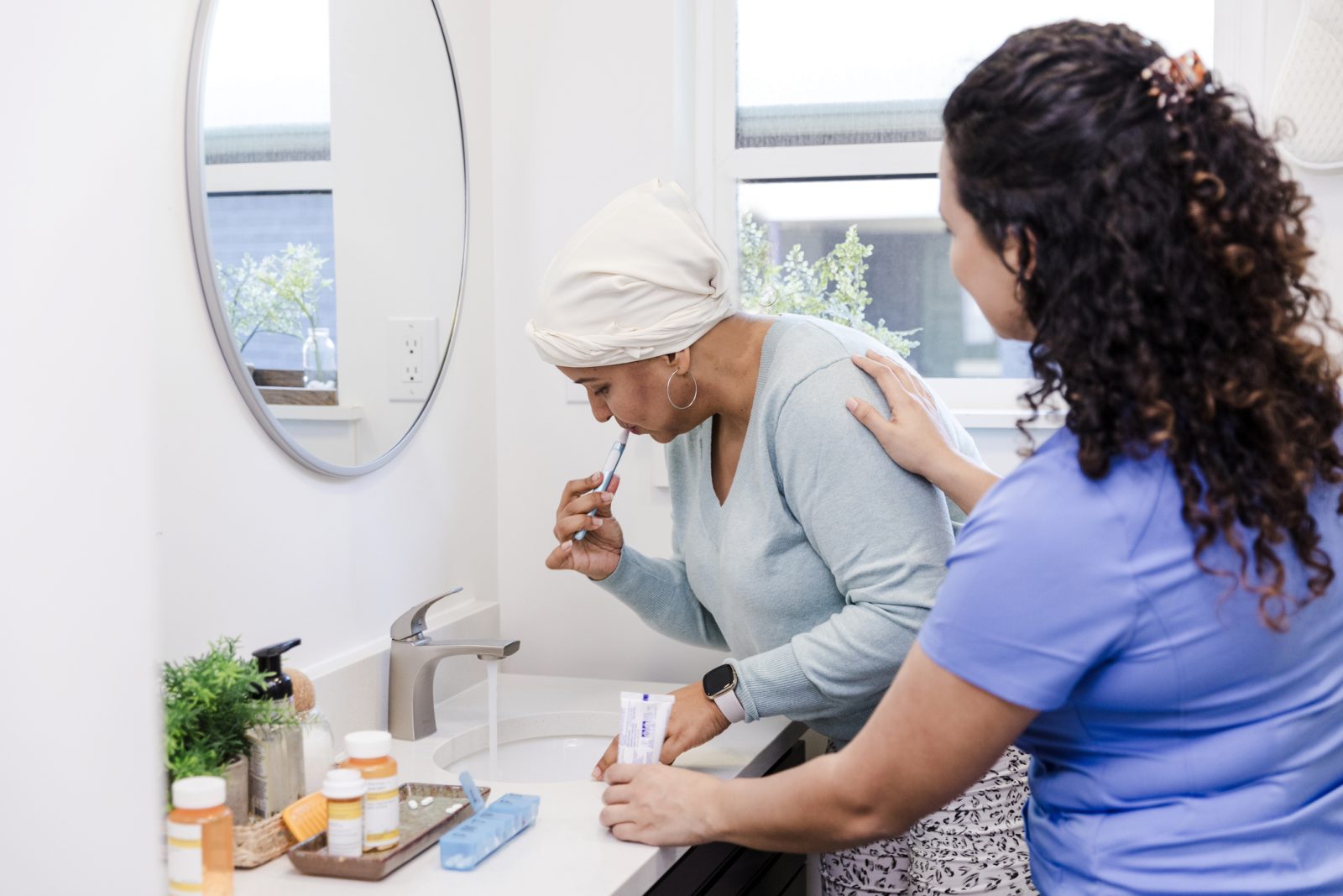 SYNERGY HomeCare caregiver helping a client brush her teeth