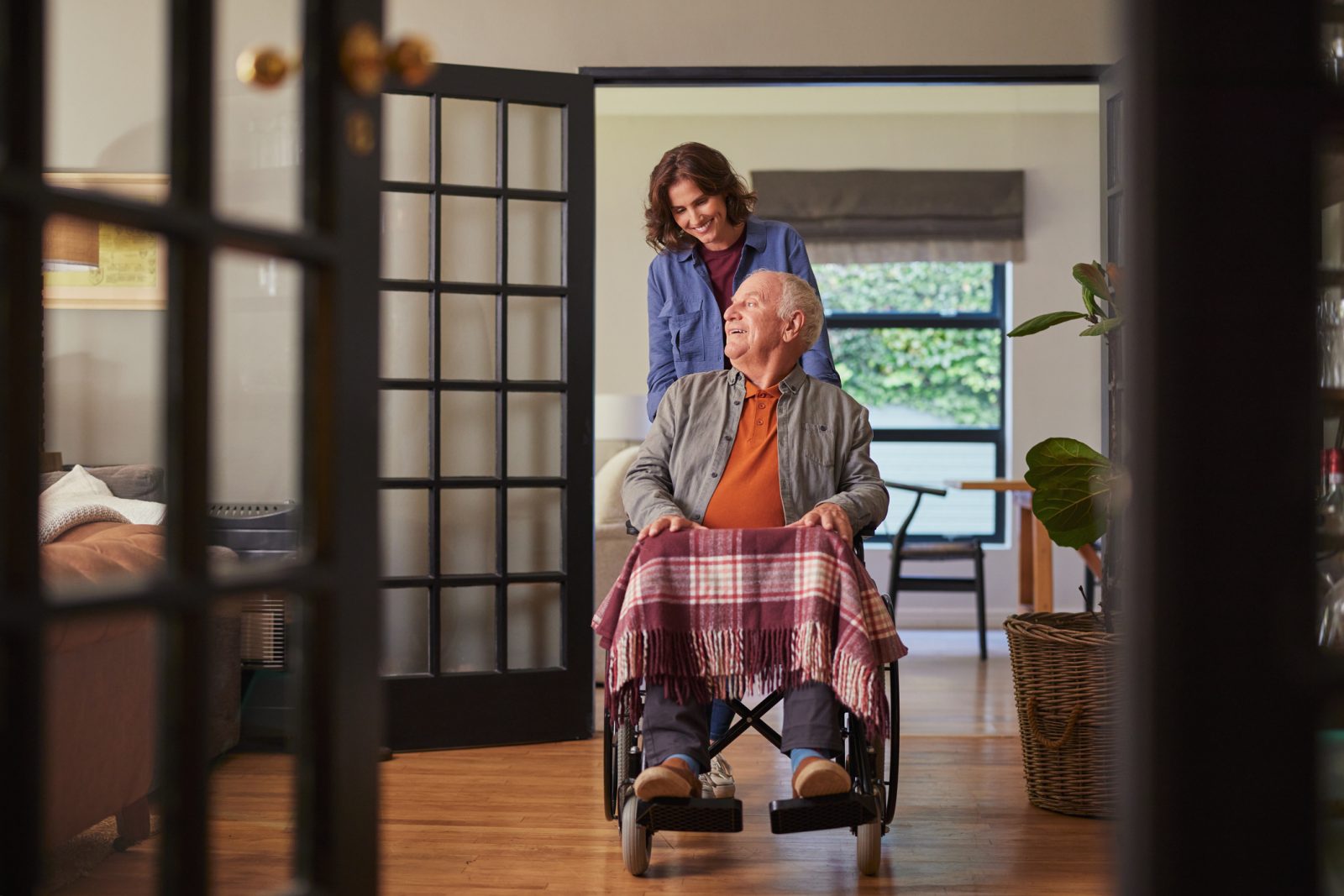 SYNERGY HomeCare caregiver pushing client in a wheelchair