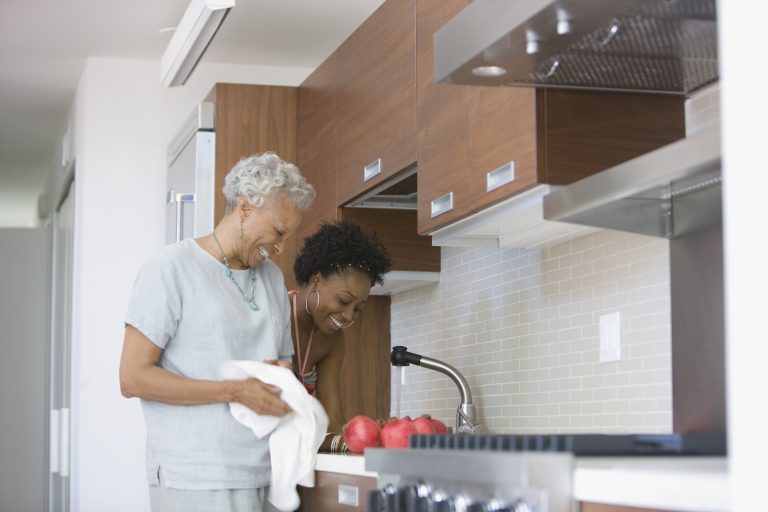 Grandmother and granddaughter preparing food in kitchen