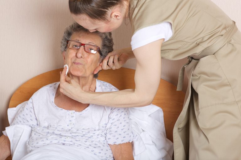 Young social work assistant takes care of a senior woman between 70 and 80 years old.