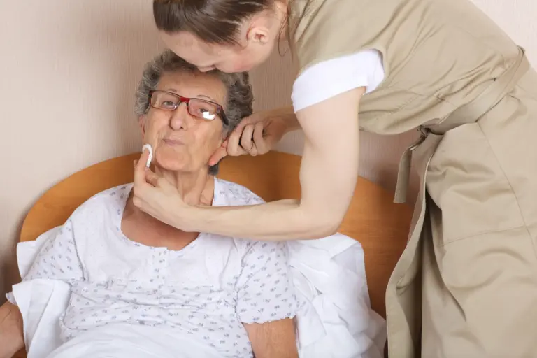Young social work assistant takes care of a senior woman between 70 and 80 years old.