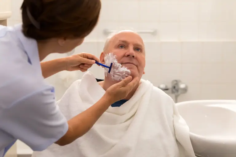 Personal hygiene – home caregiver with senior man in bathroom