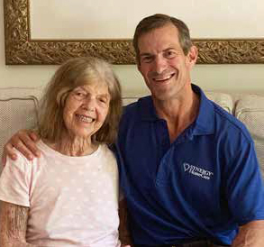 SYNERGY HomeCare of the Lowcountry's owner Mark Piegza and his mom Helen sitting on couch