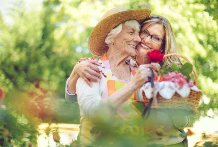 A mother and daughter gathering flowers in their garden.