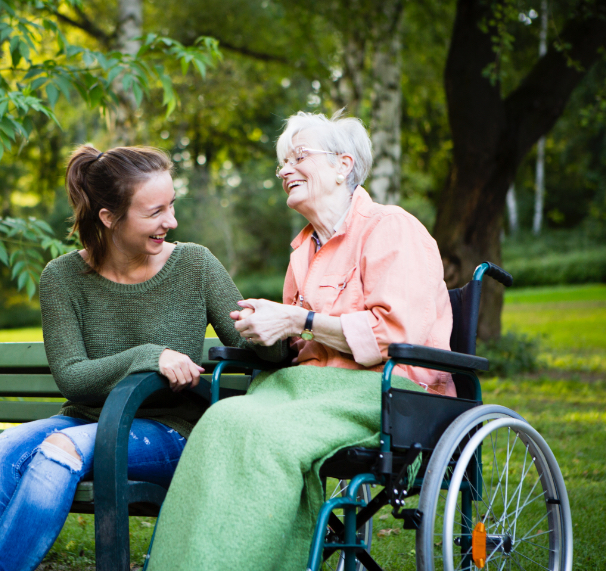 woman on bench and senior in wheel chair enjoying each other's presence
