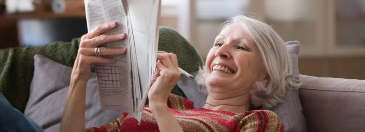 Senior woman relaxing at home while a caregiver provides respite care to take care of her aging mom.