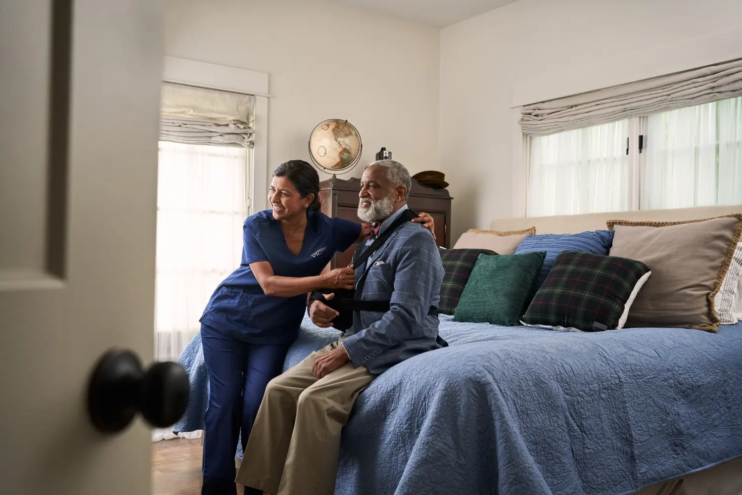SYNERGY HomeCare caregiver helping client get dressed