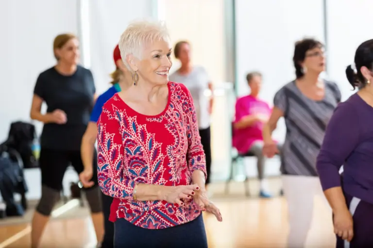 Joyful seniors enjoying a dance activity at a senior benefits center