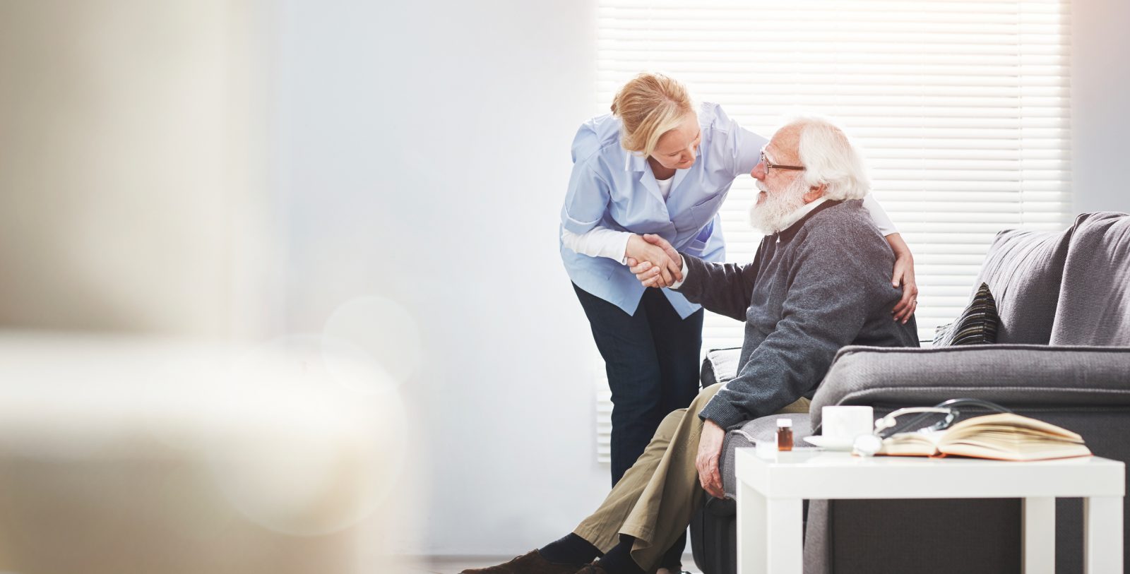Mature, loving caregiver caring for a senior patient at an assisted living home. Healthcare worker comforting a confused man suffering with alzheimer's or dementia, showing kindness and support
