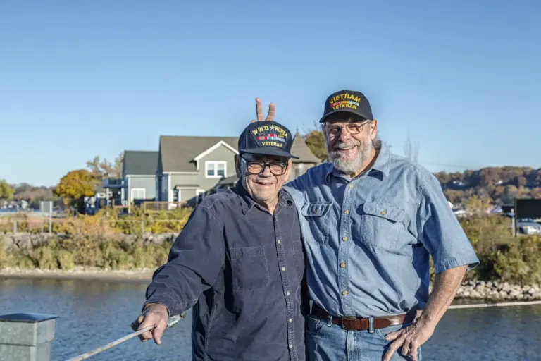Senior military men smiling outside.