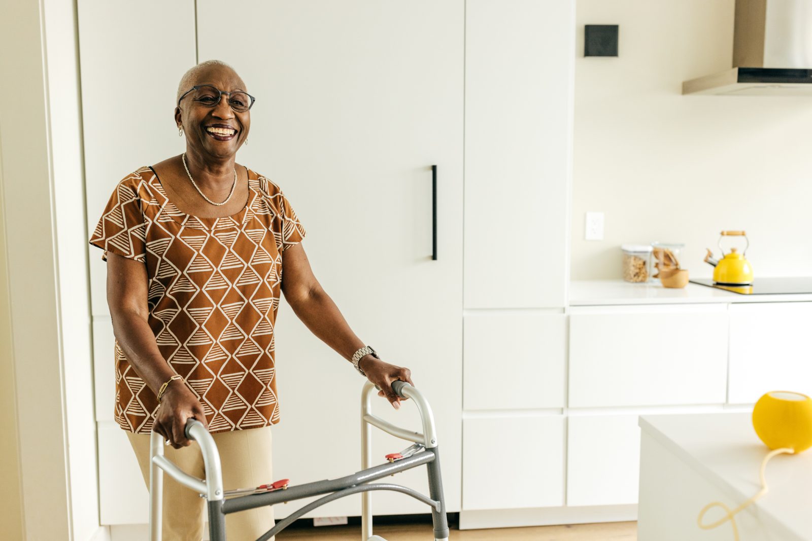 Smiling senior women with limited mobility uses a walker in her home