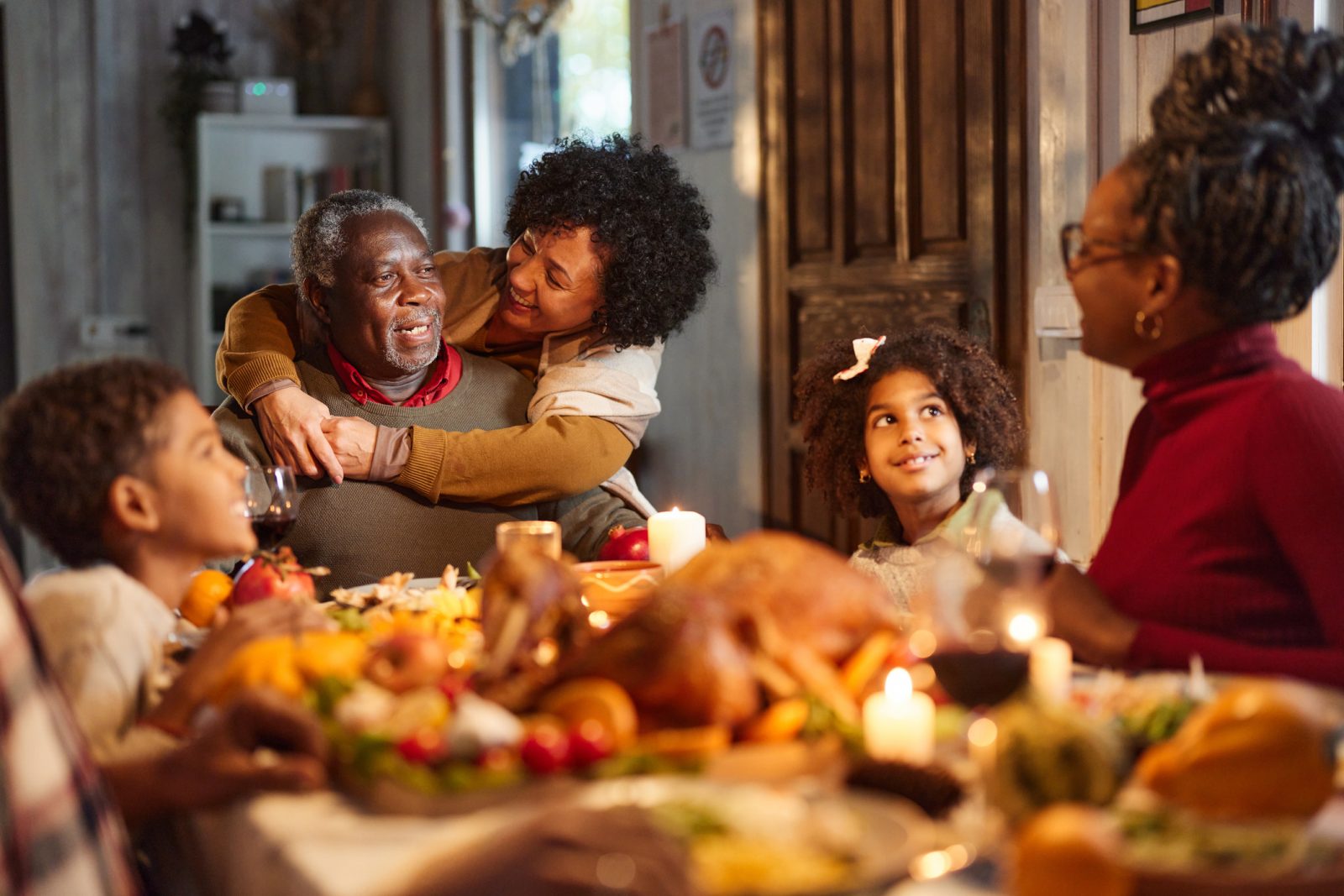 Image ALT Text: Grandparents engaging with their family during holiday dinner.