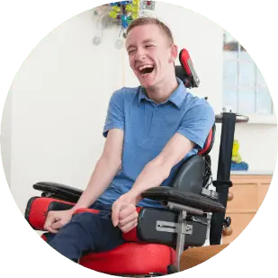 disabled boy in wheelchair laughing with a friend