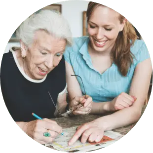 woman and senior woman enjoying doing a crossword puzzle together