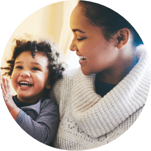 mother looking at her child while both are smiling with joy