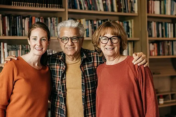 Adult daughter with her aging parents smiling