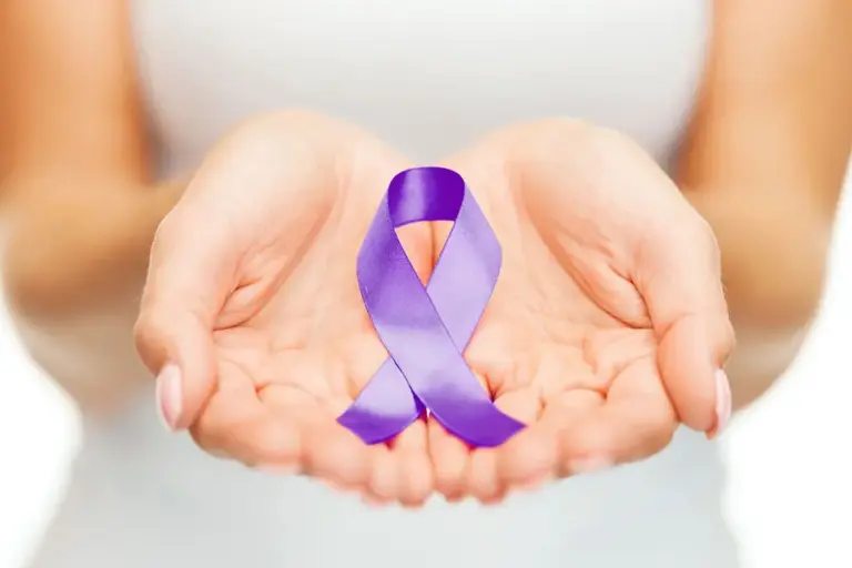 womans hands palms up holding purple ribbon in support of alzheimers