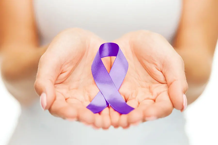 womans hands palms up holding purple ribbon in support of alzheimers