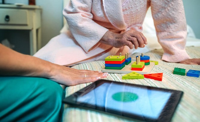 caregiver and demtentia patient working puzzle