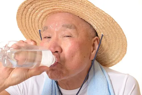 asian-older-man-in-straw-hat-drinking-from-bottled-water.jpg