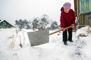 bigstock-elderly-woman-cleans-snow-near-255835282.jpg