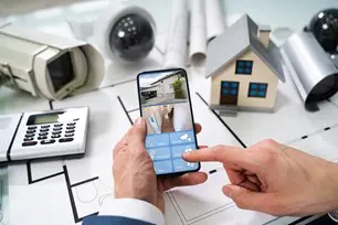 bigstock-person-hand-using-home-securit-351920501-1.jpg