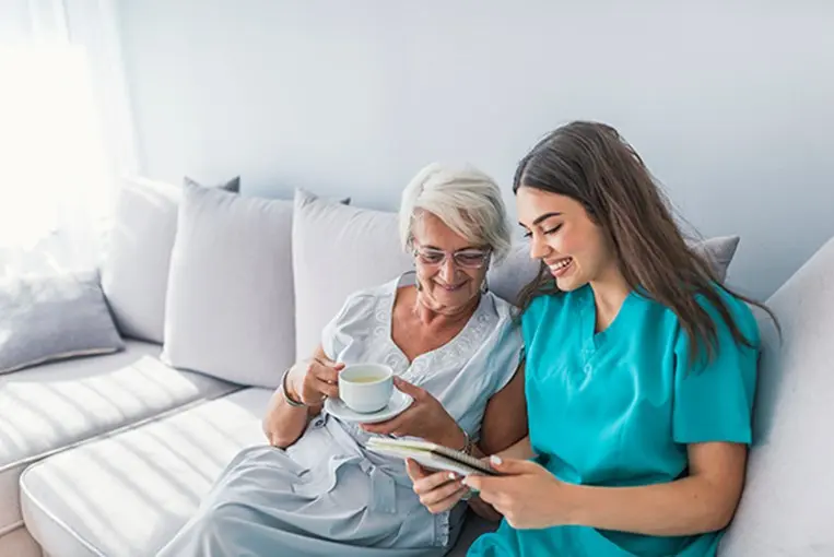 female caregiver sitting on couch with client talking