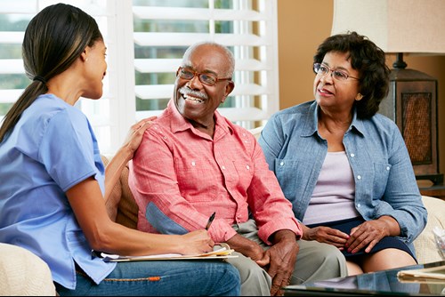 Caregiver talking with senior couple