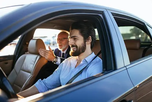 young man driving senior man