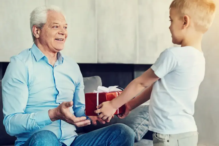 young grandson handing grandfather a present