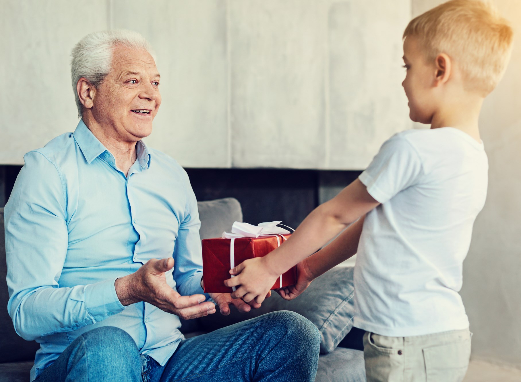 young grandson handing grandfather a present