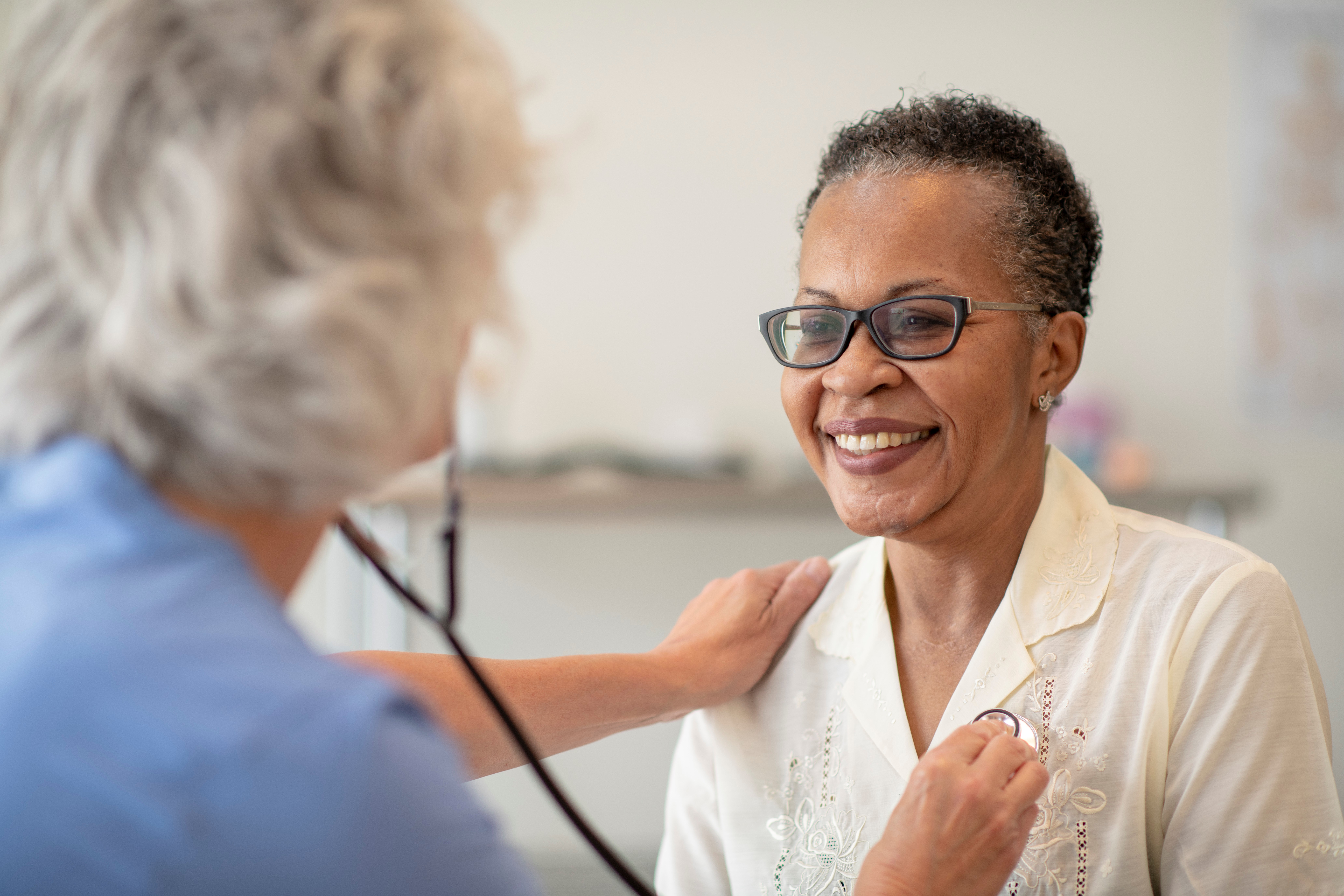 nurse listening to senior womans heart