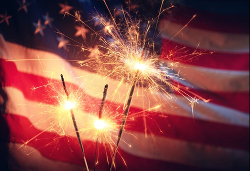 american flag with sparklers in front of it july 4