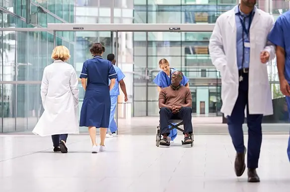 man in wheelchair leaving hospital
