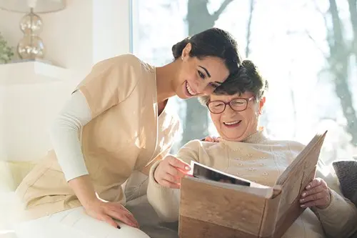 caregiver and memory client viewing photo album