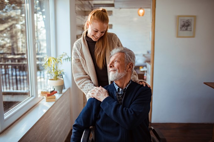 Girl assisting man in wheelchair
