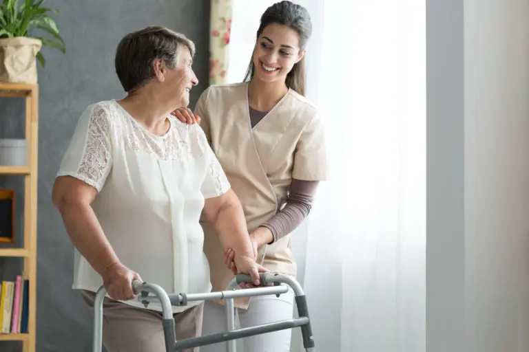 senior woman in walker being helped by caregiver for seniorspost hospital recovery
