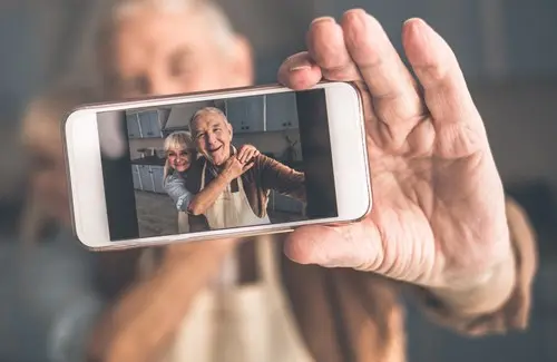 senior couple holding phone with selfie showing