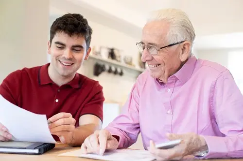 senior man smiling working with his young mentor
